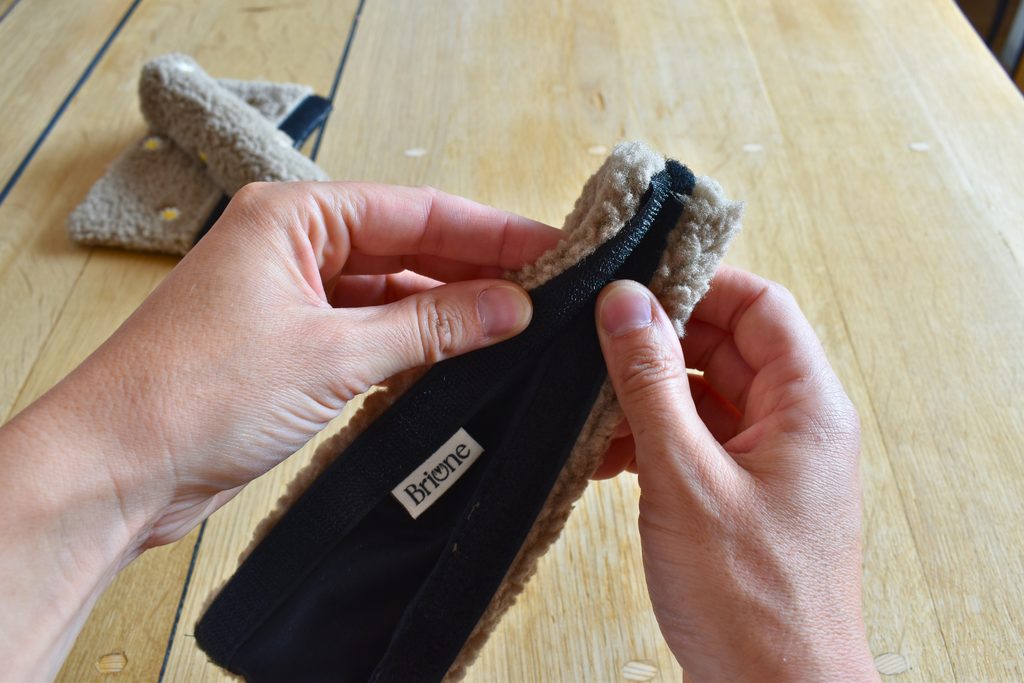 Mains qui ouvrent les scratchs d'un fourreau de licol en sherpa brun, dans l'atelier briune, 